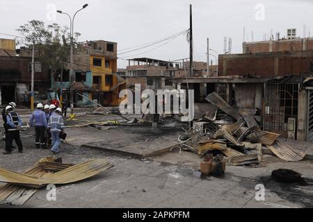 Lima, Perù. 23rd Gen 2020. Gli agenti di polizia e i soccorritori si trovano vicino ai detriti delle case dopo l'esplosione di una petroliera a gas a Villa el Salvador, nel sud di Lima, in Perù. Un camion che trasportava gas naturale esplose uccidendo almeno due persone e ferendo circa 48 poliziotti ha detto. L'esplosione ha causato il fuoco di diverse case. Credit: Mariana Bazo/Zuma Wire/Alamy Live News Foto Stock