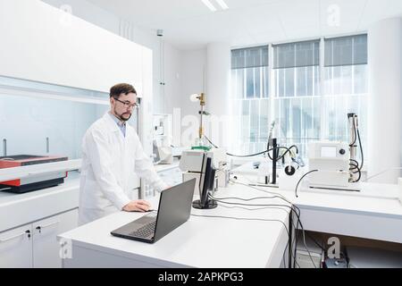 Scienziato che usa il computer in laboratorio di centro tecnologico Foto Stock