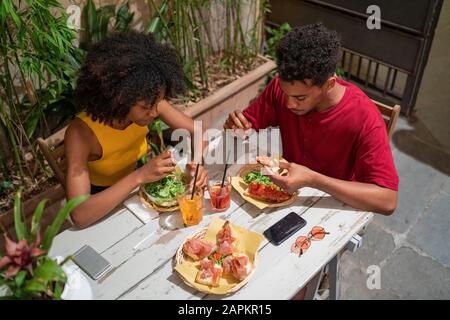 Giovane coppia con un drink e un antipasto in un bar all'aperto Foto Stock
