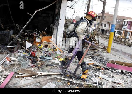 Lima, Perù. 23rd Gen 2020. I vigili del fuoco nei pressi dei detriti delle case dopo un'esplosione di una petroliera a gas a Villa el Salvador nel sud di Lima, Perù. Un camion che trasportava gas naturale esplose uccidendo almeno due persone e ferendo circa 48 poliziotti ha detto. L'esplosione ha causato il fuoco di diverse case. Credit: Mariana Bazo/Zuma Wire/Alamy Live News Foto Stock