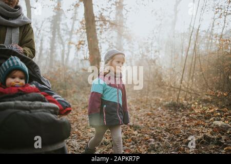 Madre con figlie durante la passeggiata nella foresta in autunno Foto Stock