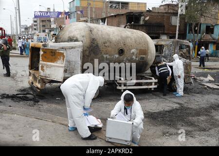 Lima, Perù. 23rd Gen 2020. Gli operai forensi si trovano vicino ai detriti di una petroliera dopo essere esplosi a Villa el Salvador, Lima meridionale, Perù. Un camion che trasportava gas naturale esplose uccidendo almeno due persone e ferendo circa 48 poliziotti ha detto. L'esplosione ha causato il fuoco di diverse case. Credit: Mariana Bazo/Zuma Wire/Alamy Live News Foto Stock