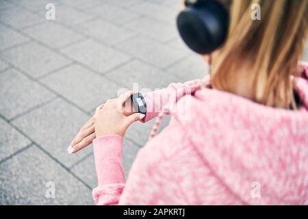 Giovane donna che controlla l'app fitness dopo l'allenamento Foto Stock