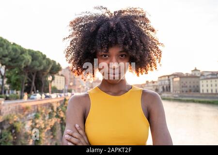 Ritratto di una giovane donna sicura sul fiume Arno al tramonto, Firenze, Italia Foto Stock