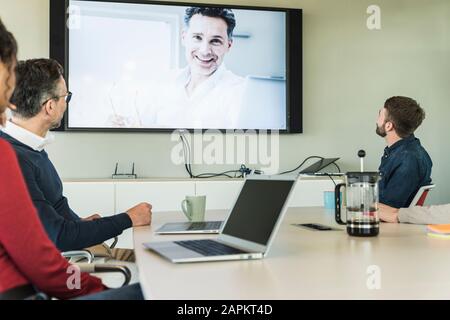 Le persone in viaggio d'affari hanno una videoconferenza in sala riunioni Foto Stock