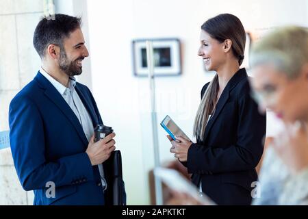 Sorridente business persone che parlano in ufficio Foto Stock