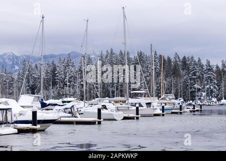 Vancouver, Canada - 15 gennaio 2020: Vista del molo ghiacciato con le barche a Coal Harbour. Neve tempesta e condizioni meteorologiche estreme a Vancouver. Foto Stock