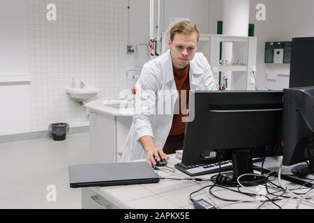 Scienziato che usa il computer in laboratorio di centro tecnologico Foto Stock