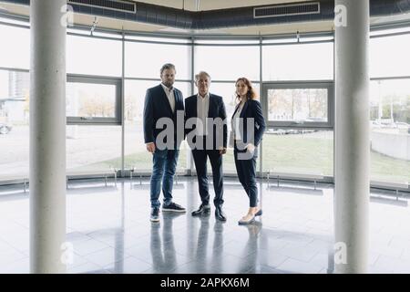 Ritratto di persone d'affari fiduciose che si trovano in un moderno edificio d'ufficio Foto Stock
