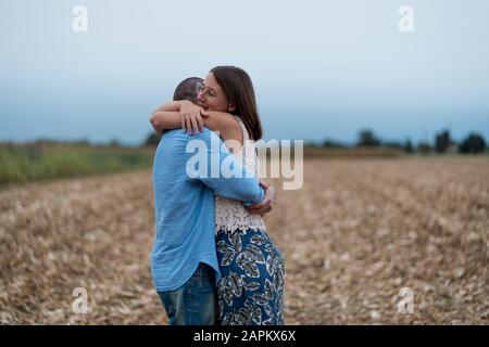 Coppia nell'amore che abbraccia su un campo Foto Stock