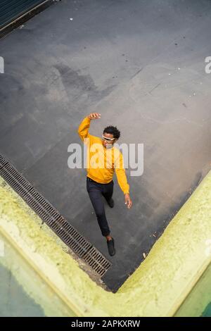 Uomo maturo con giacca gialla e in piedi sulla corsia Foto Stock