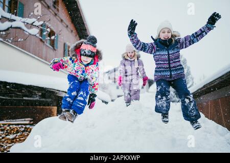 Tre bambini che giocano nella neve, Jochberg, Austria Foto Stock