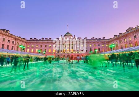 UK, Inghilterra, Londra, persone pattinaggio su ghiaccio in pista di ghiaccio verde di fronte a Somerset House Foto Stock