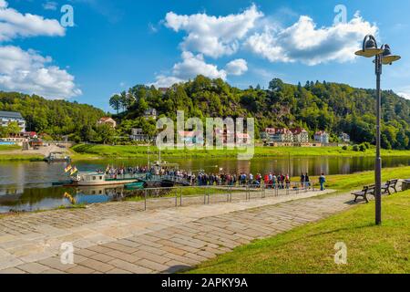 Germania, Sassonia, Rathen, un grande gruppo di persone che aspettano in fila per salire a bordo di un battello ormeggiato sul fiume Elba Foto Stock