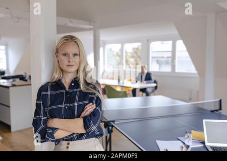 Ritratto di giovane donna d'affari in ufficio con tavolo da ping pong Foto Stock
