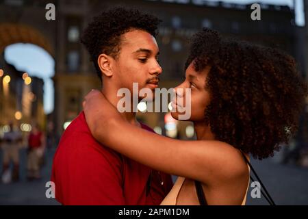 Affettuosa giovane coppia turistica in città al tramonto, Firenze, Italia Foto Stock