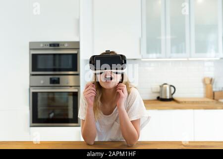Adolescente femminile in cucina con occhiali VR Foto Stock