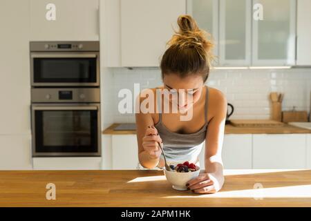 Adolescente femminile durante la colazione in cucina Foto Stock