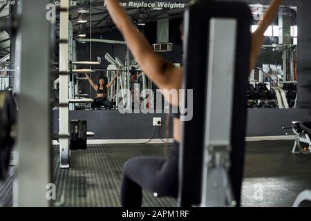 Atleta femminile sollevamento pesi in palestra Foto Stock