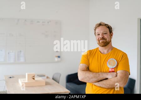 Ritratto di un uomo d'affari sicuro e informale con un premio in ufficio Foto Stock