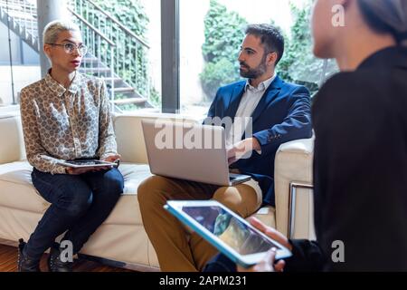 Colleghi che lavorano insieme in salotto Foto Stock