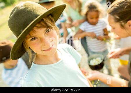 Scuola bambini imparare, come preparare un'infusione camomilla, ragazza sorridente alla macchina fotografica Foto Stock