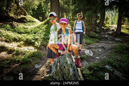 Ritratto di madre con due bambini che camminano in paesaggio alpino, Val Passiria, Alto Adige, Italia Foto Stock