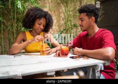 Giovane coppia con un drink in un bar all'aperto Foto Stock