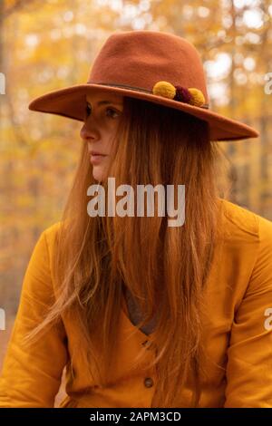 Ritratto di giovane donna alla moda redheaded con cappello in feltro nella foresta autunnale Foto Stock