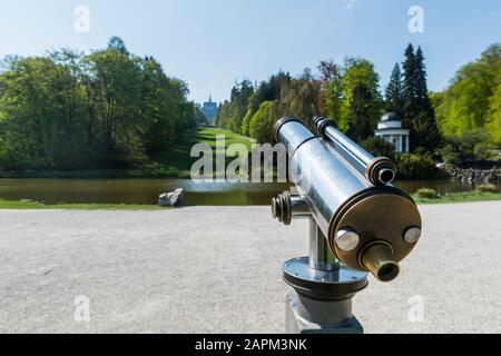 Germania, Assia, Kassel, Coin hanno operato binocoli di fronte allo stagno nel Bergpark Wilhelmshohe Foto Stock