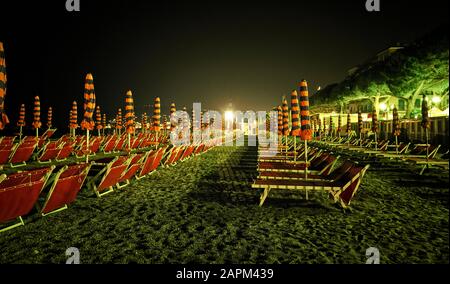 Spiaggia con sedie a sdraio di notte, San Bartolomeo al Mare, Italia Foto Stock