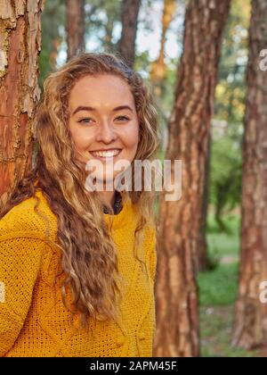 Ritratto di giovane donna felice in una pineta Foto Stock