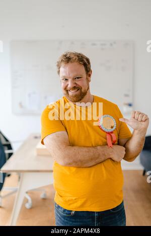 Ritratto di un uomo d'affari felice casuale con un premio in ufficio Foto Stock