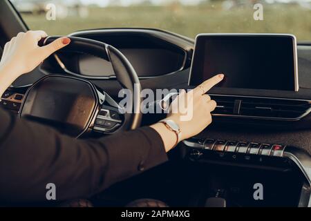 Giovane donna che usa il dispositivo di navigazione in auto Foto Stock