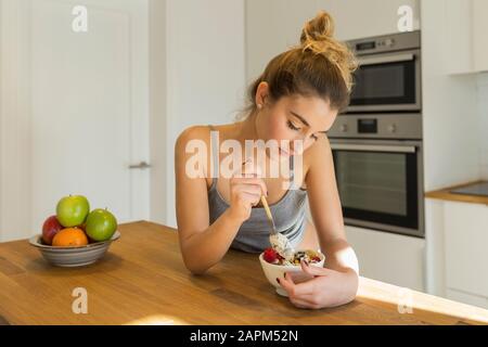 Adolescente femminile durante la colazione in cucina Foto Stock