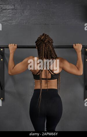 Allenamento atletica femminile su barra in mento, vista posteriore Foto Stock