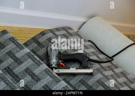 Scala con tappeto di installazione su tappeto volvente a sinistra sul pavimento Foto Stock