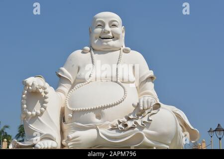 Buon Buddha Seduto nel Sunshine e nel cielo blu in Vietnam Foto Stock