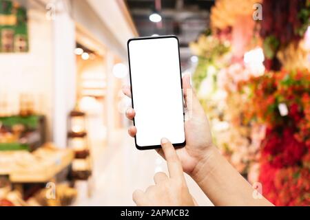 Mockup smartphone mano tenendo schermo vuoto per il testo o la vostra pubblicità grafica sul telefono cellulare per l'acquisto casa decorazione mock up sfondo conce Foto Stock
