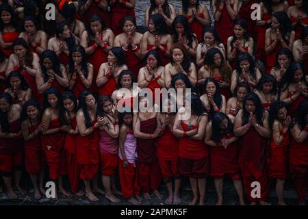 Kathmandu, Nepal. 24th Gen 2020. Le donne nepalesi si levano in piedi sulle rive del fiume Bagmati mentre offrono le preghiere durante il mese-lungo festival di Swasthani Bratakatha, dedicato alla dea Shree Swasthani al tempiale di Pashupathinath a Kathmandu, Nepal il venerdì 24 gennaio 2020. Credit: Skanda Gautam/Zuma Wire/Alamy Live News Foto Stock