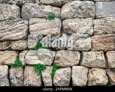 Antico muro in pietra di grandi calcari ad Atene, nella regione Attica in Grecia. Enormi blocchi antichi di pietra accatastati fino a formare un muro. Foto. Foto Stock