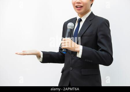 Uomo d'affari sorridente, che parla tenendo il microfono durante la conferenza. Foto Stock