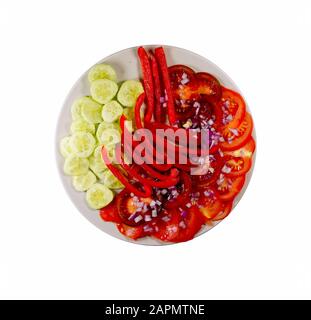 Pomodori rossi, pomodori marroni (cioccolato), pepe rosso, fette di cetriolo e cipolla rossa a dadini. Un piatto pieno di verdure tritate. Foto Stock
