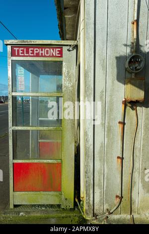 Una cabina telefonica Crusty Red a Westport, Washington, Stati Uniti Foto Stock