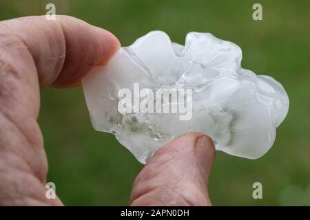 Grandine pietra tenuta in mano dopo tempesta tuono Foto Stock