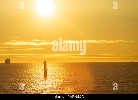 Faro nello stretto tra le isole dell'arcipelago di Stoccolma, illuminato dai raggi del sole, al mattino presto. Foto Stock