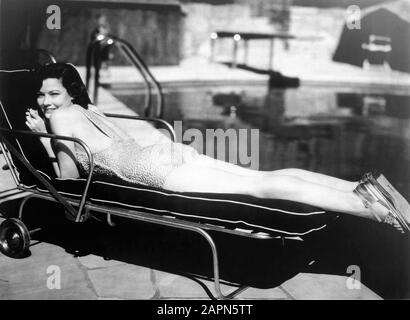 Gene TIERNEY 1940 prima foto pubblicitaria in costume da bagno su lettino da piscina Twentieth Century Fox Foto Stock