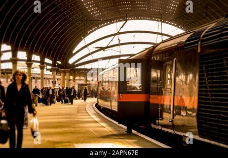 Passeggeri e treno sulla piattaforma alla stazione ferroviaria di York, Regno Unito. Foto Stock