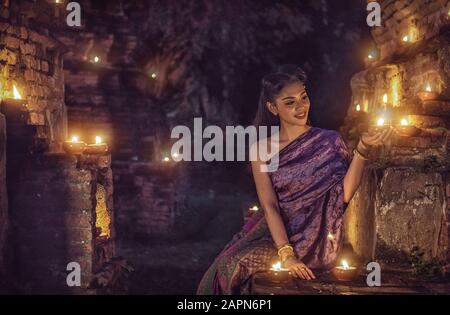 Bella ragazza tailandese in costume tradizionale tailandese con candela di notte Foto Stock