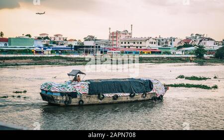 Saigon, Vietnam - 5 Ottobre 2019. Nave cargo in legno che corre sul fiume al tramonto. Con il passare del tempo, il fiume Saigon divenne parte integrante dei ricchi Foto Stock